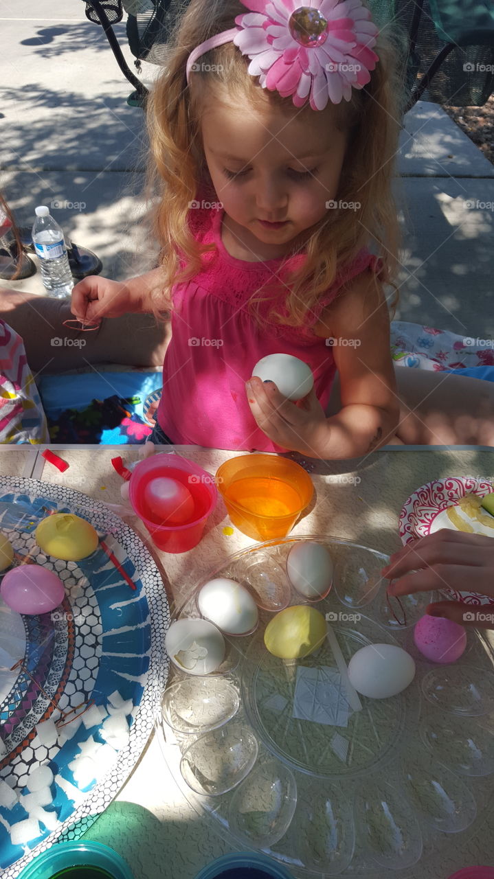 Cute girl making Easter egg
