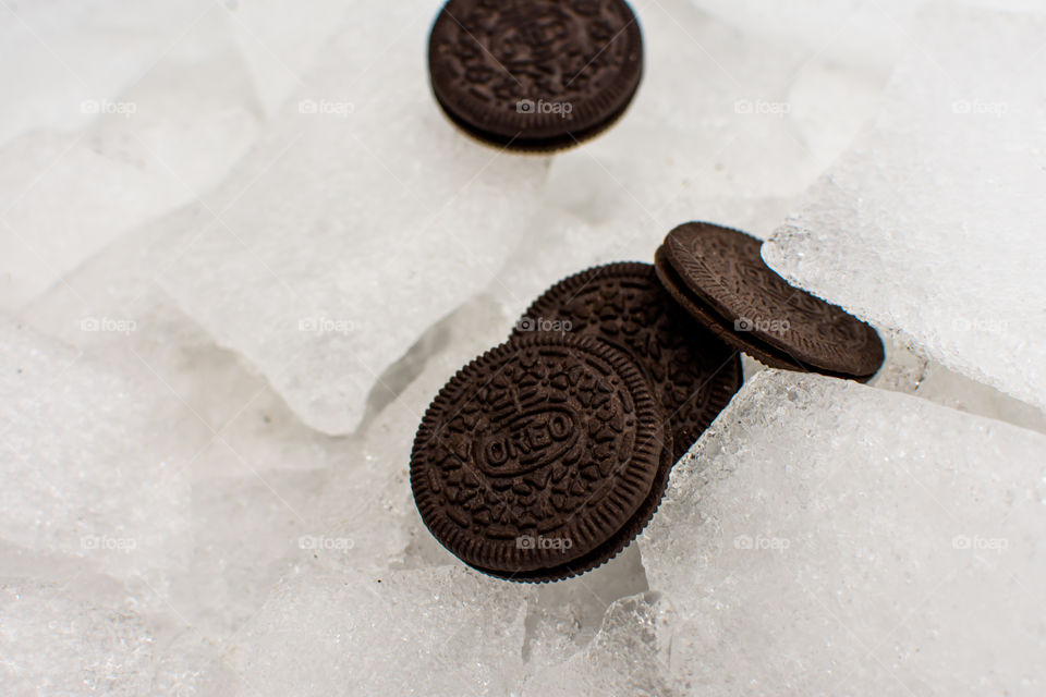 Contrast Cool Oreo Cookies artistic shot of Oreo Cookies on arctic terrain ice pieces and ice covered snow plies of fun Oreos travelling on winter background thin and thick Oreo Cookies art photography 