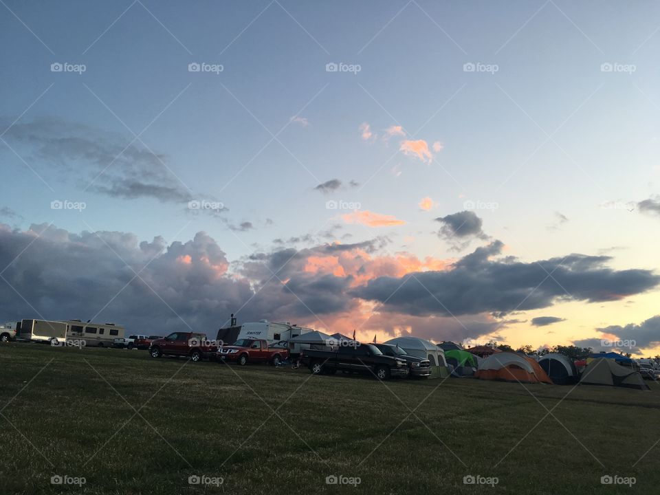 Sunset over the field of tents, trailers, trucks, and flags that is NASCAR Brooklyn Michigan 