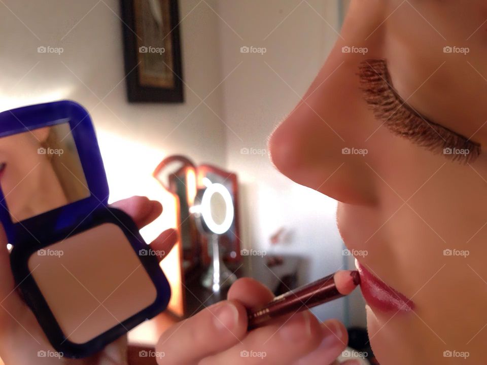 Woman applying cosmetics.