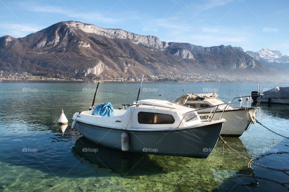 Taken in Annecy, France. A lovely and beautiful clear lake (Lake Annecy) featuring mountains, and a boat