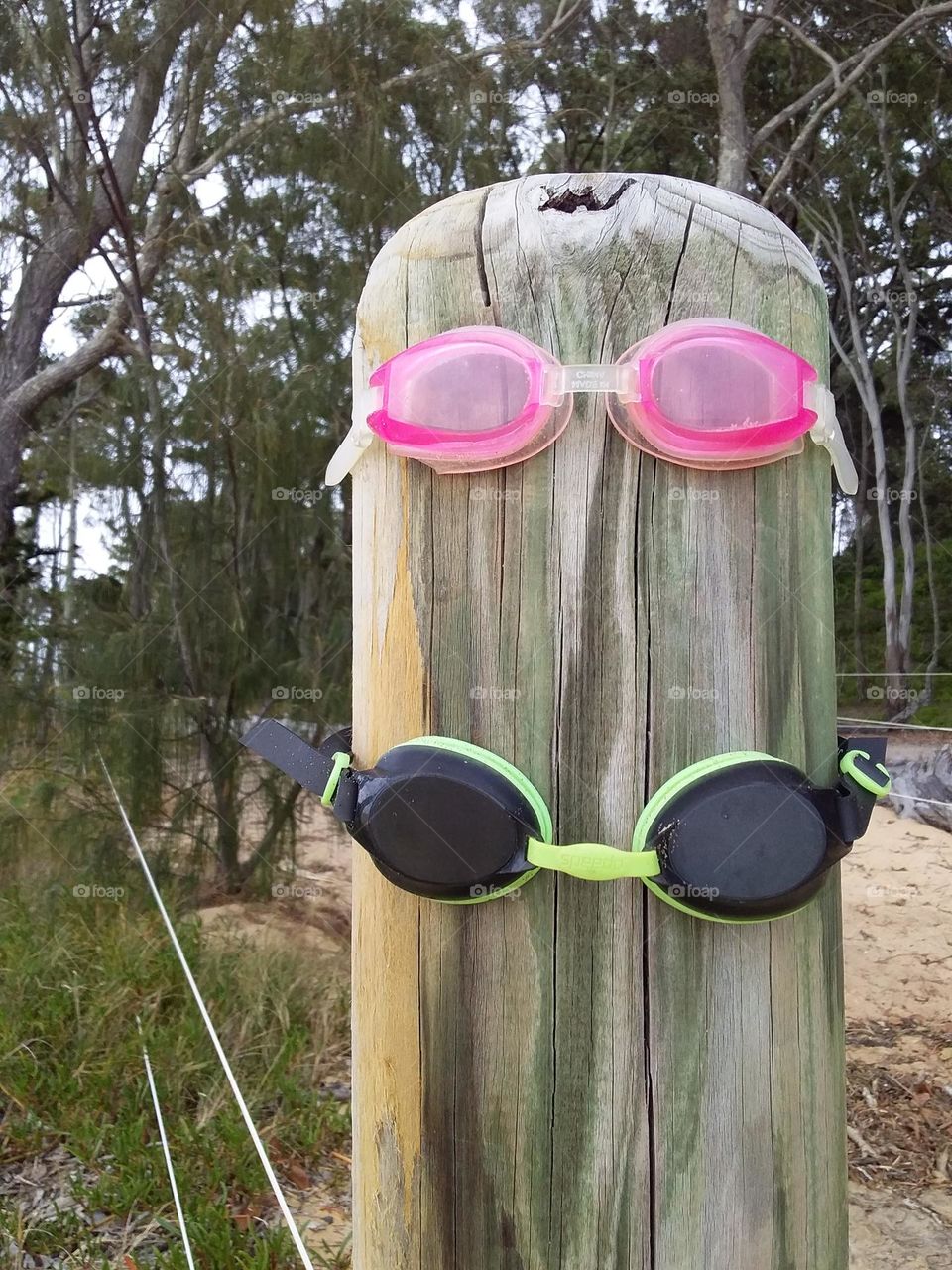 swimming goggles on a post at the beach