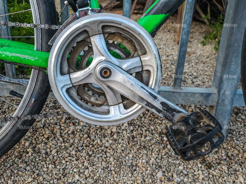 Vintage electric green bicycle along a fence highlighting the petal 