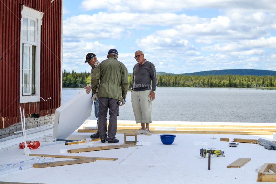 Three men in a discussion about a extanstion of a house