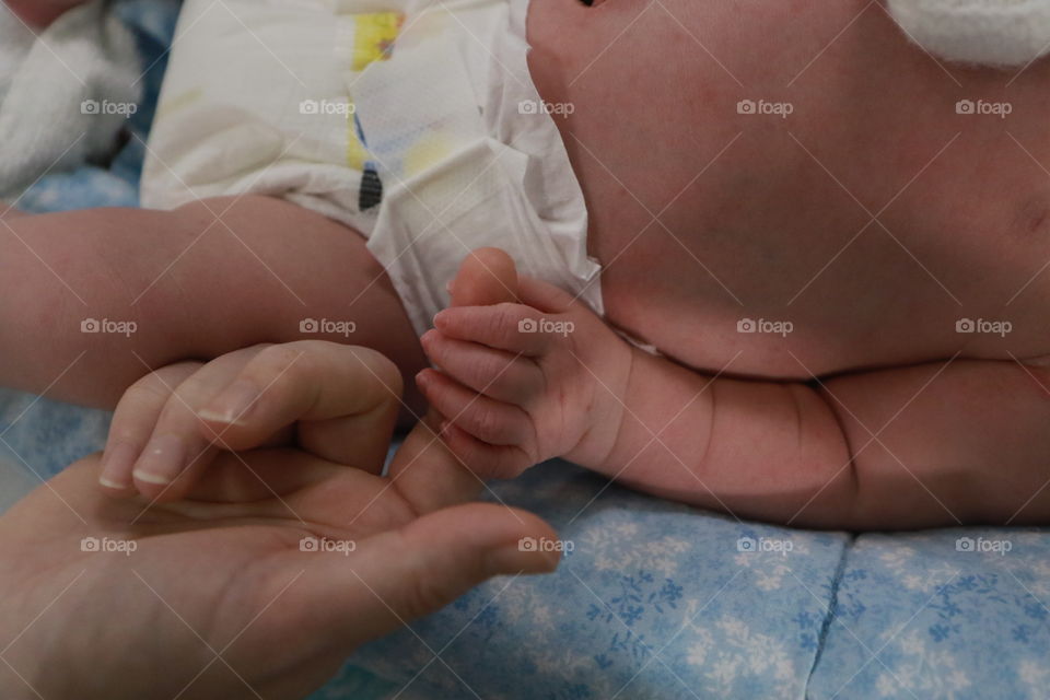 Holding hands with a newborn in a humidicrib