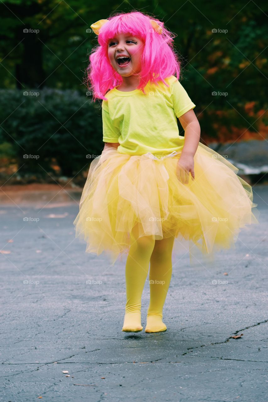 Girl in pink wig walking on street