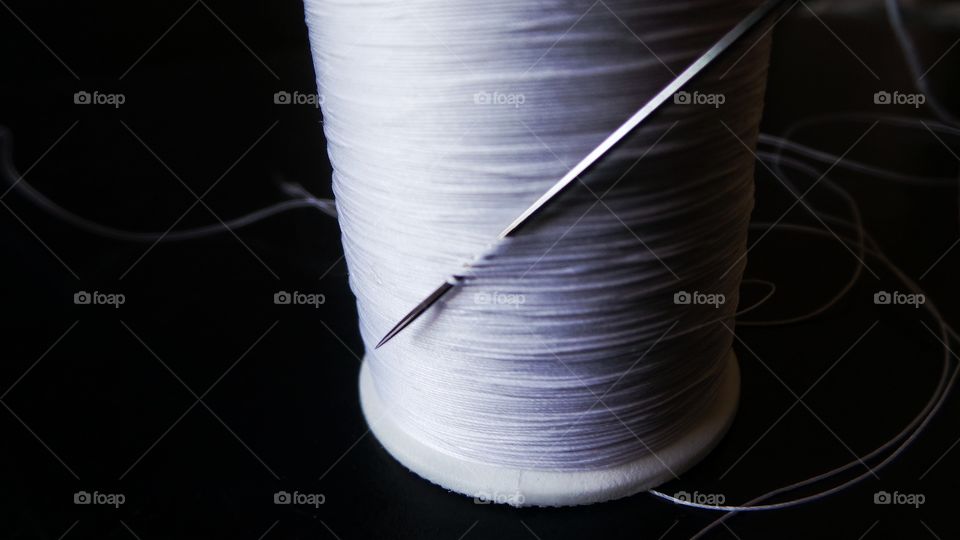 Thread strands holding needle