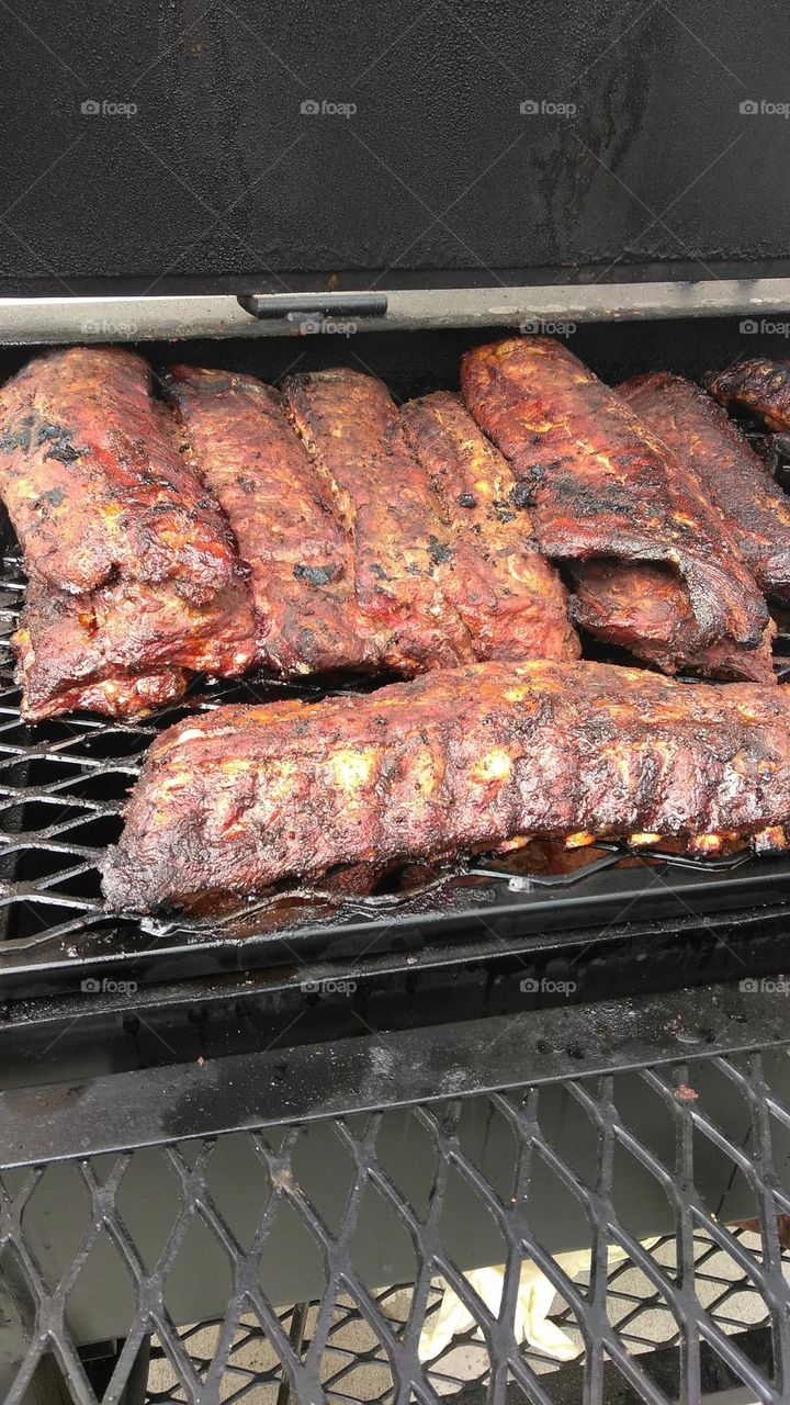 pork ribs being slow cooked to perfection on a outdoor grill