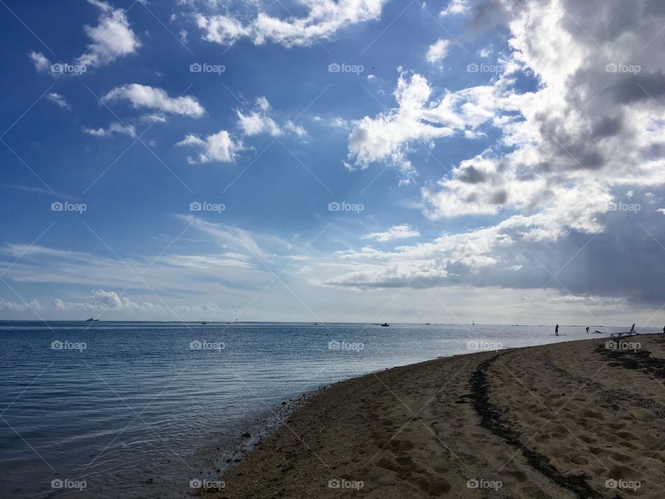 The horizon looks over on the Indian Ocean as paddle boarders flow foward.
