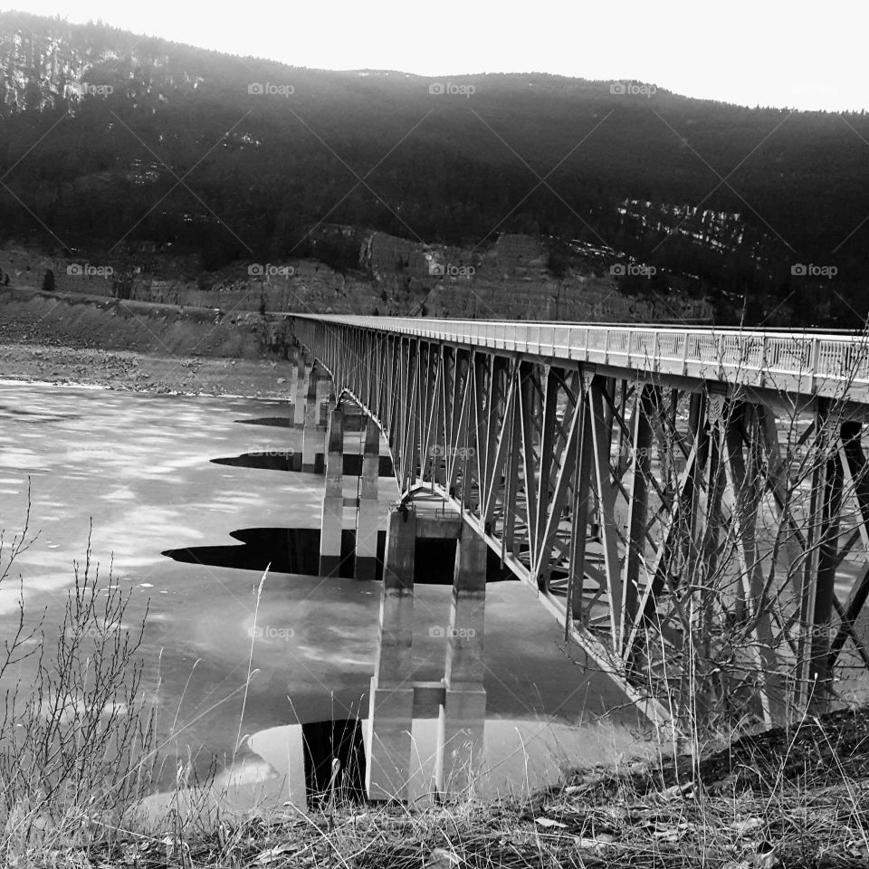 steel bridge over frozen water black and white