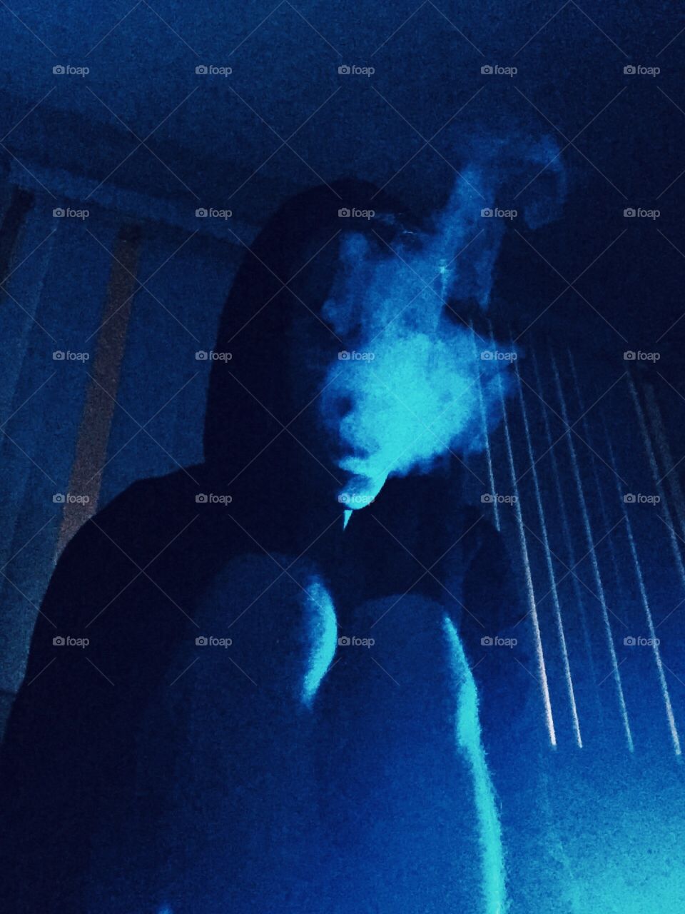 lonely toker. A boy sits at night half naked and smoking an unknown substance