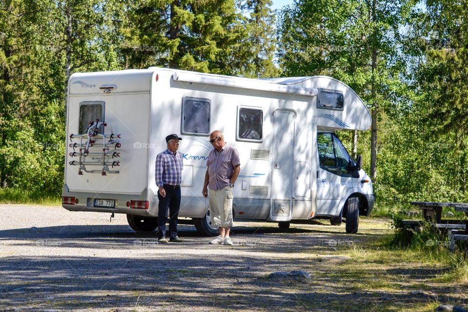 Two people talking outside a camper