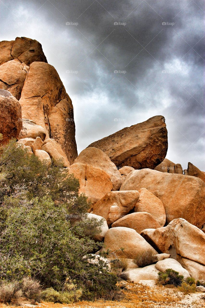 Stunningly beautiful rock formations at Joshua Tree National Park in California, with a cloud cover in the sky like a storm is brewing 