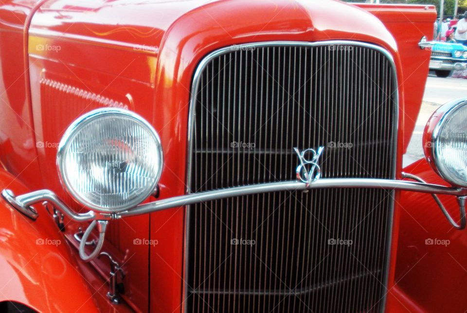 red classic car close-up of grill and headlight