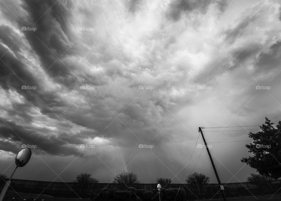 Storm clouds and a rainbow in black and white.