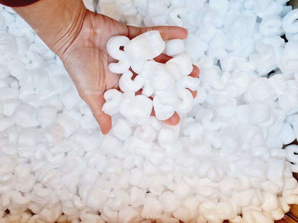 hand grabs polystyrene packaging for shipping