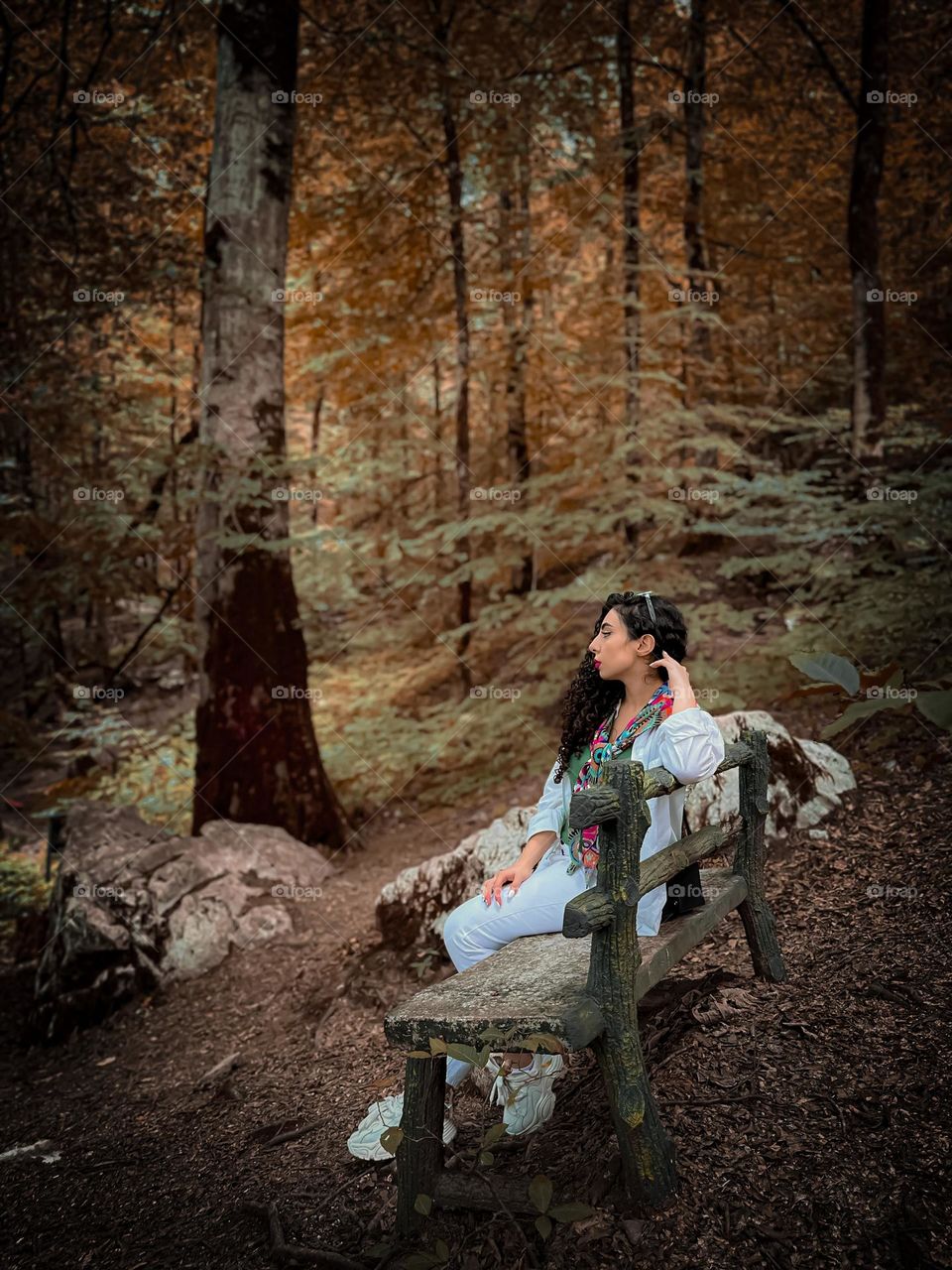 Curly haired girl watching the beauty of the forest