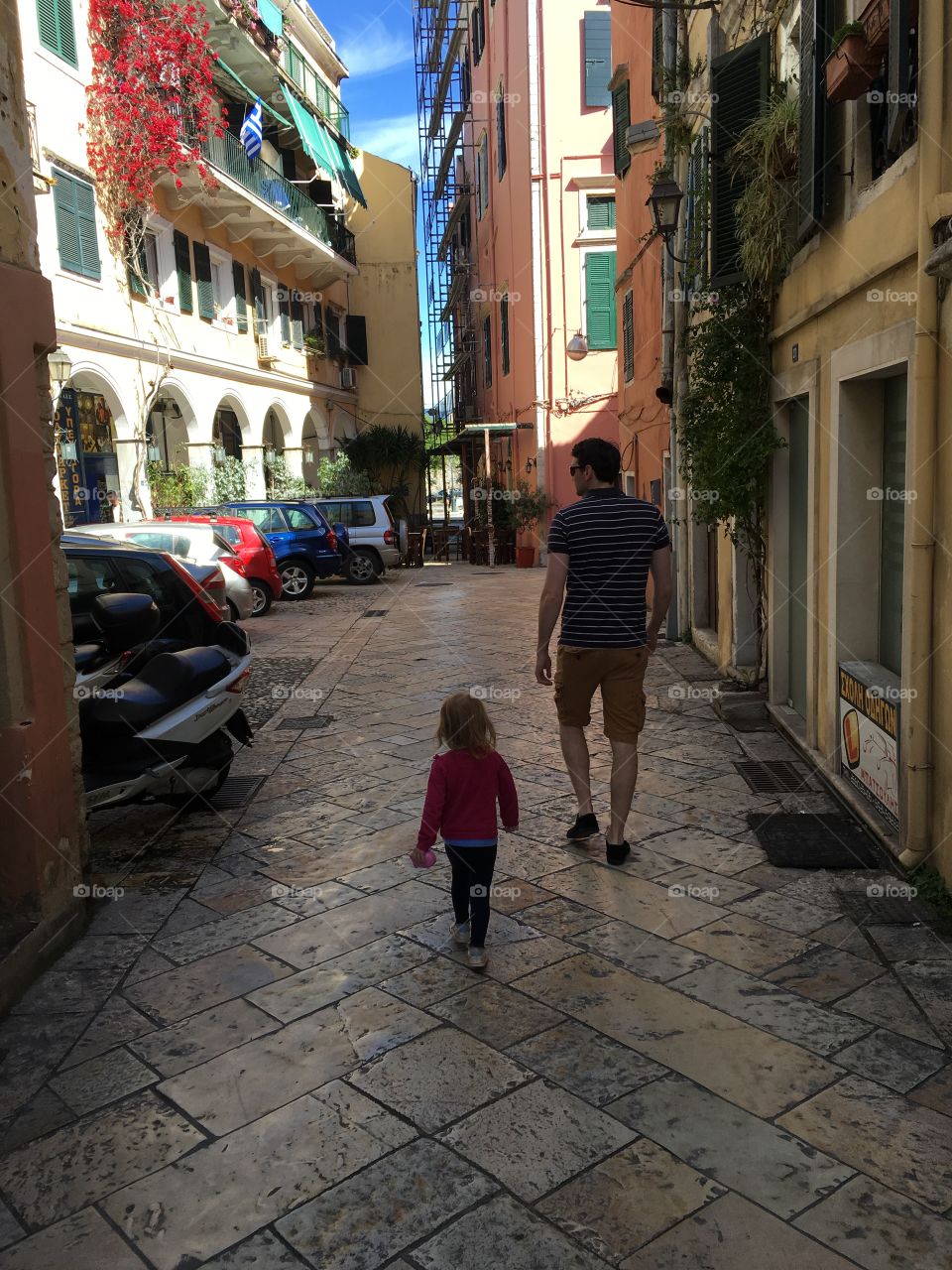 Father and daughter exploring the streets of Corfu Town, Greece