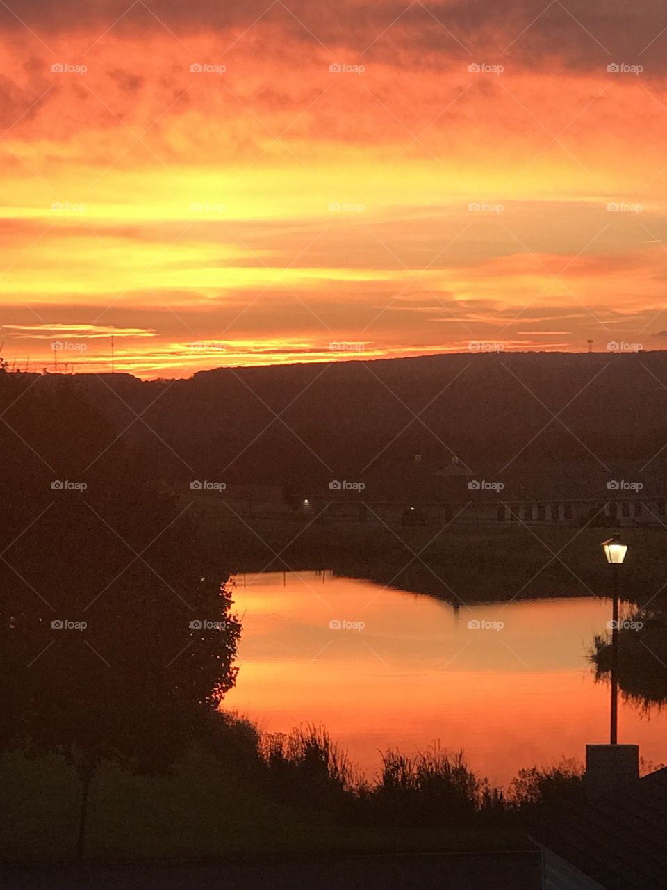 Gorgeous orange sunrise reflecting over a pond. 