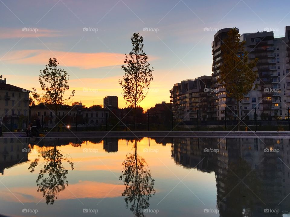 Building reflecting in lake during sunset