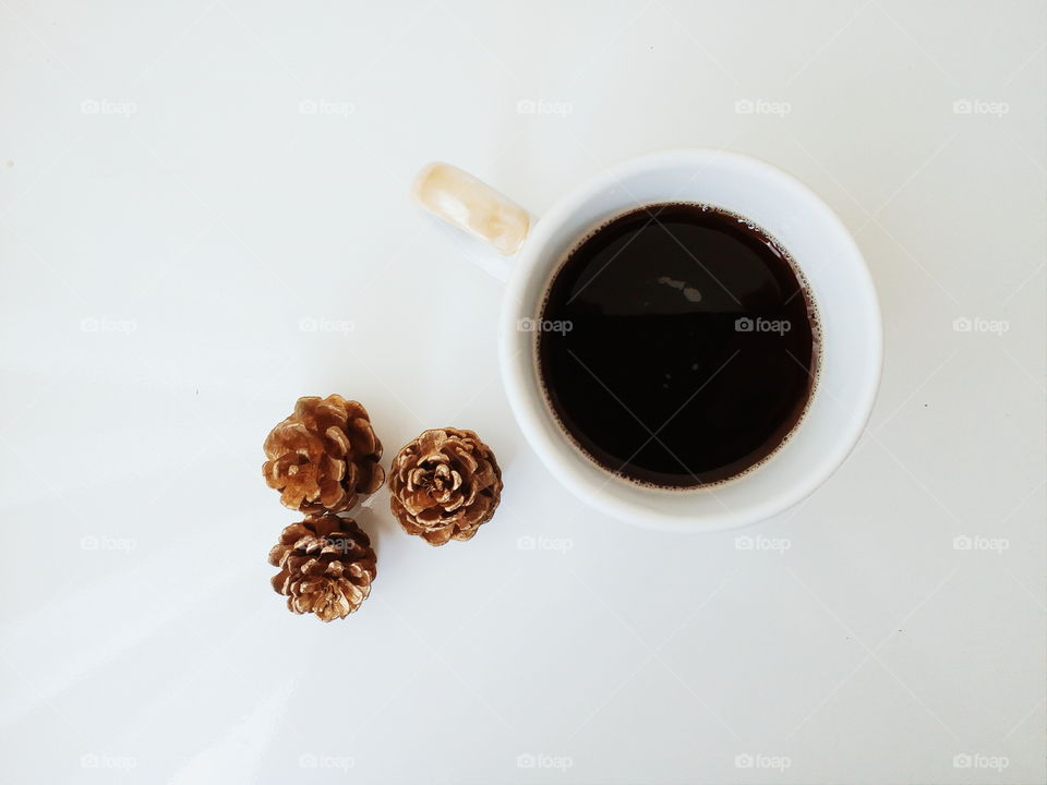 Elevated view of coffee cup with pine cone