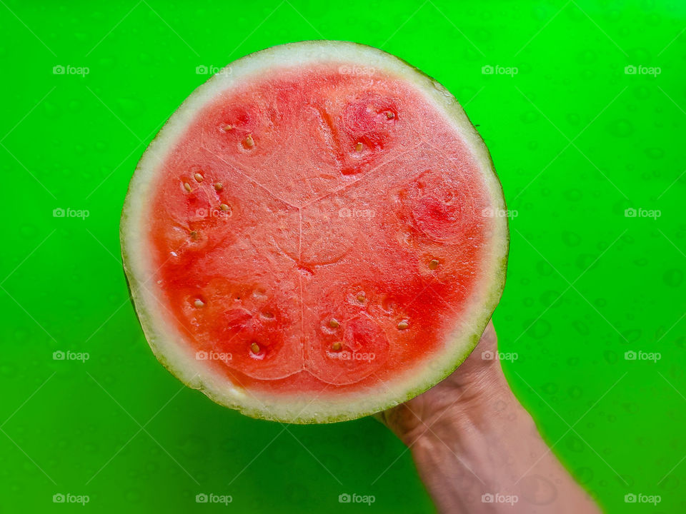 watermelon half on a lime green wet background