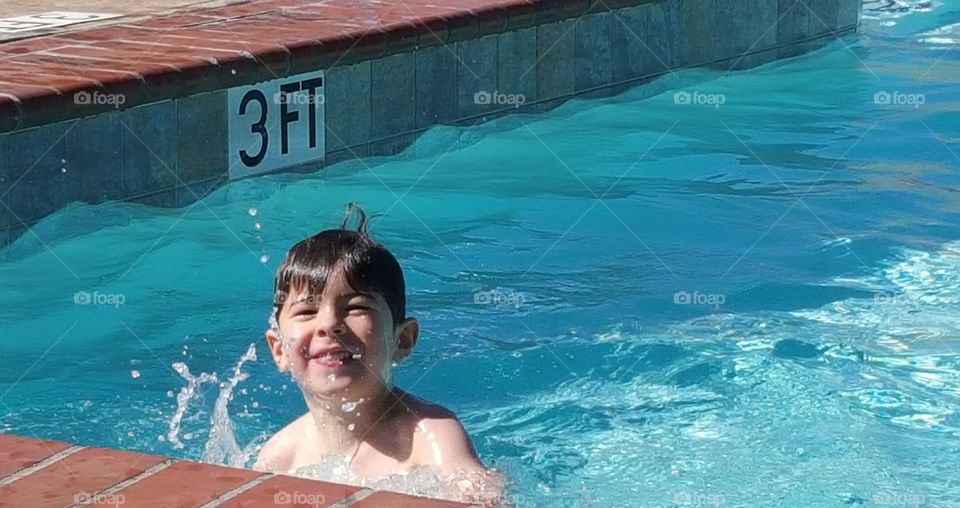 A smiling boy swimming in pool