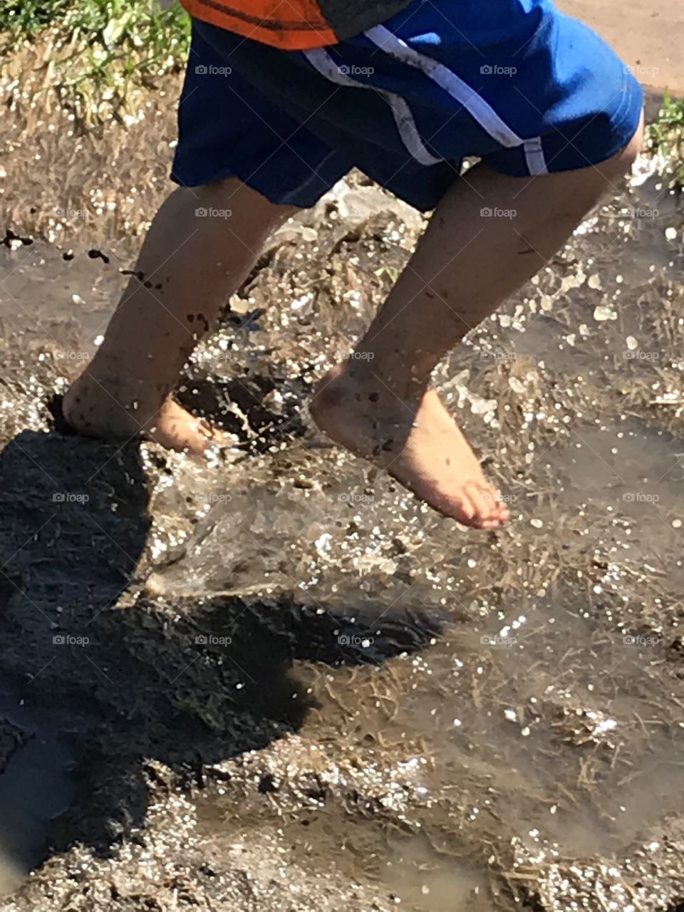 Young child running through mud