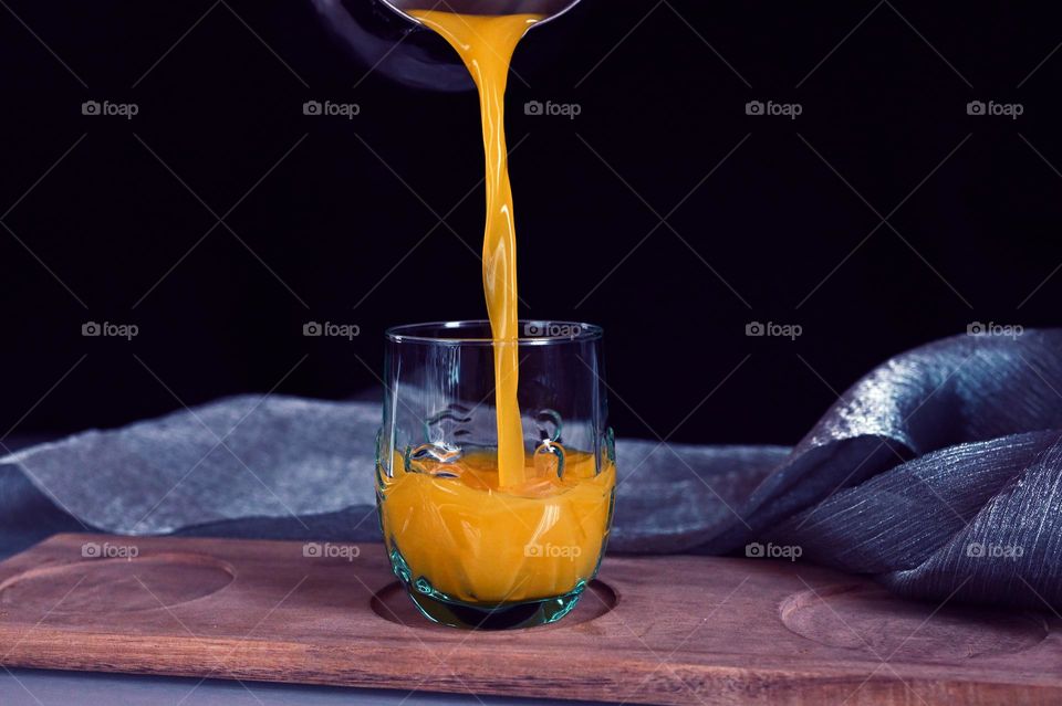 pour orange juice into a glass