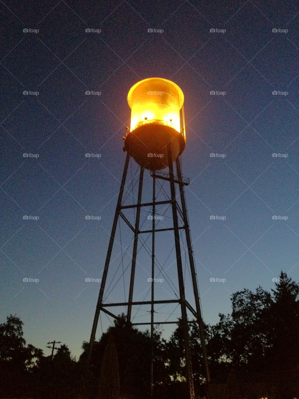 Illuminated water tower at night.. Illuminated water tower at night. iPhone photo