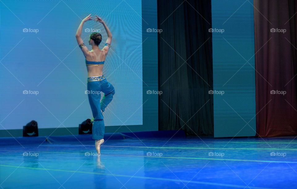 Ballerina and oriental dance, young dancer on stage.