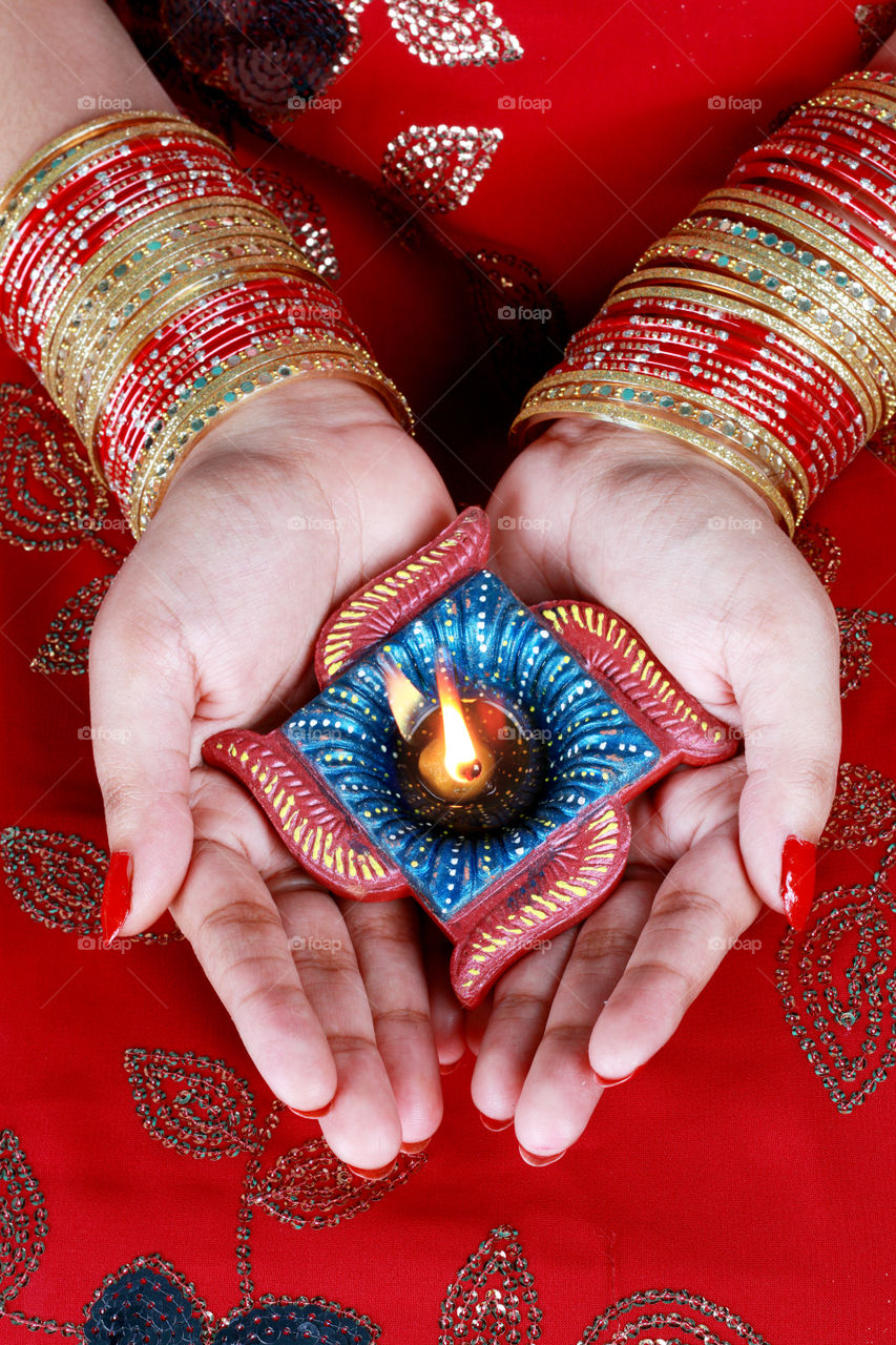 Indian festival Diwali diya oil lamp on female hand