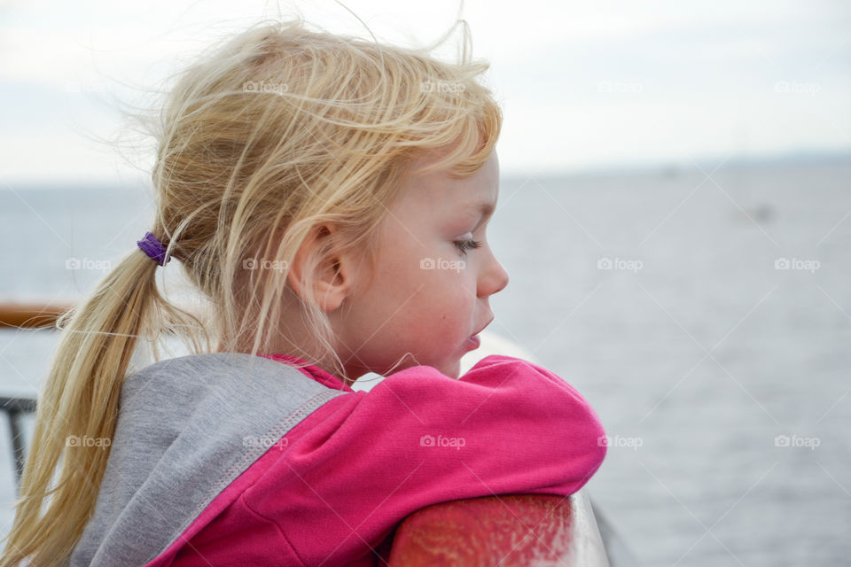 Thoughtful young girl looking out to sea.