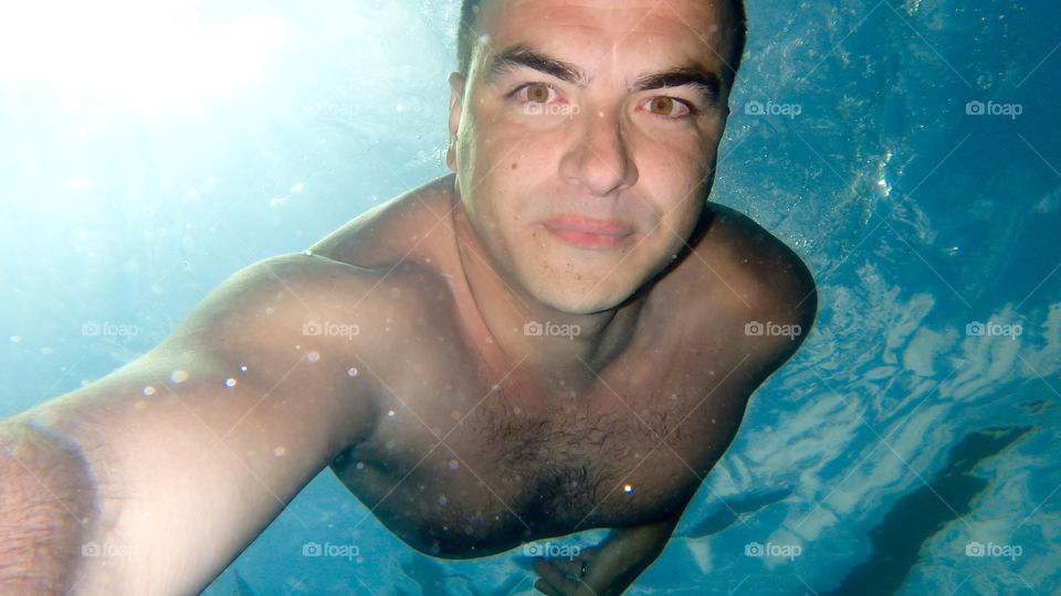 Underwater view of a man taking selfie