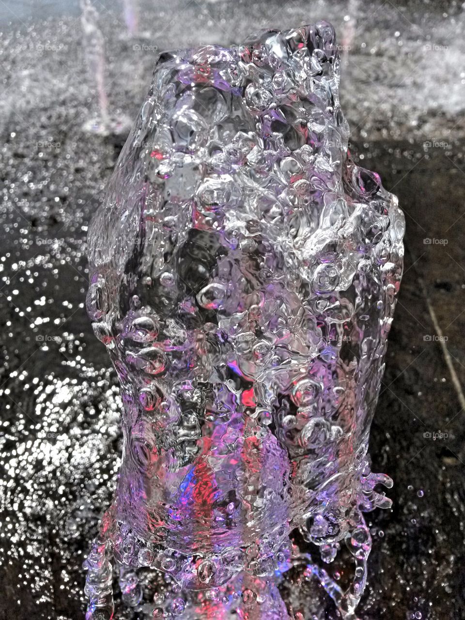 water in motion: Close up of water splash from a fountain with colored light