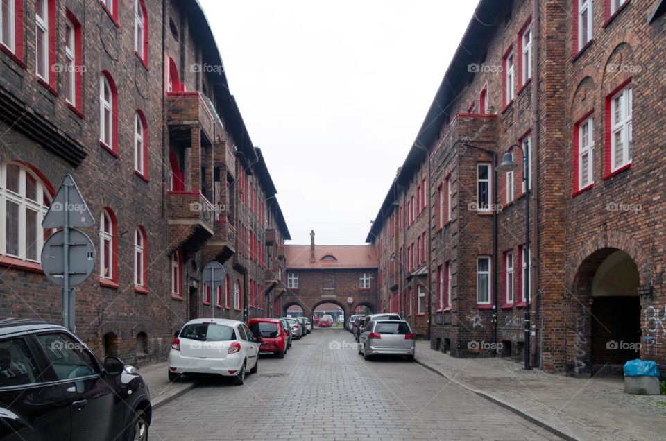 Cars on road amidst buildings against clear sky.