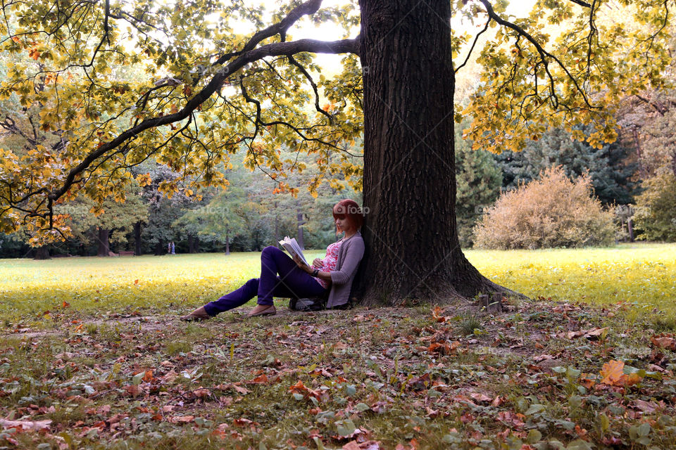 Woman reading book under the tree