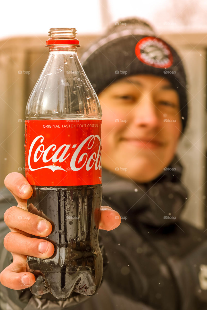 Happy teenager with a bottle of coca cola