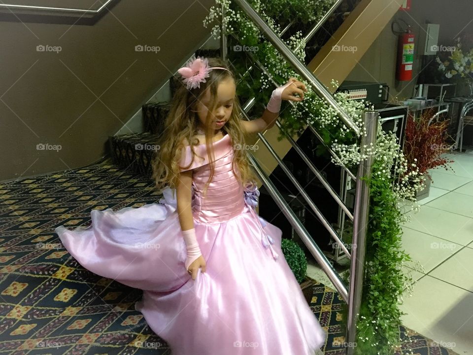 Girl in pink dress moving down through staircase