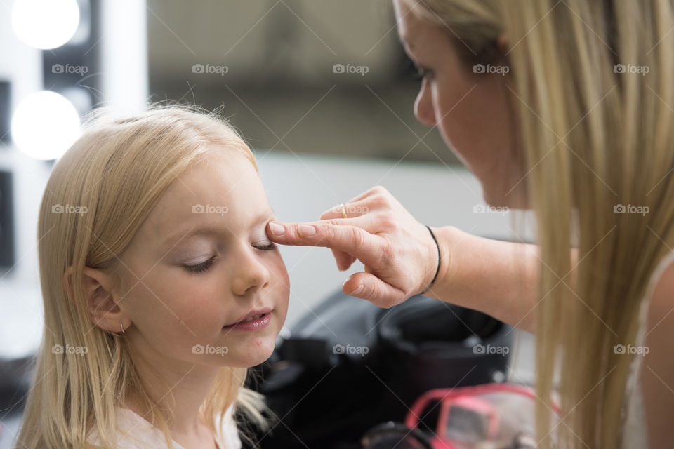 Mother styling her 6 year old doughter with makeup before a photoshoot. (For fun)