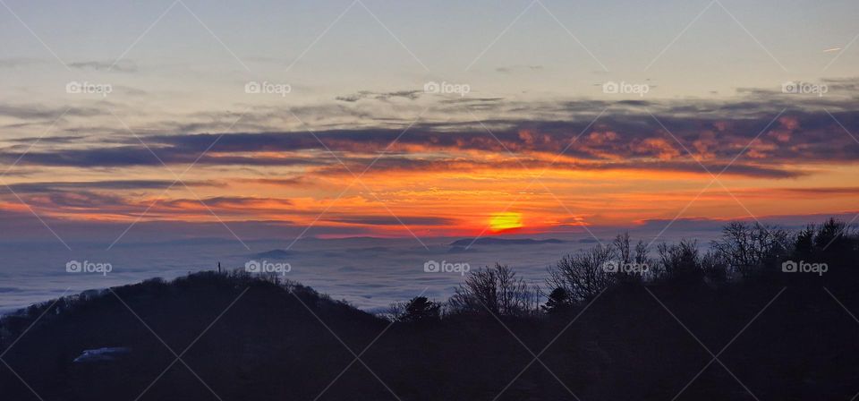 Beautiful sunset above clouds from mountain top