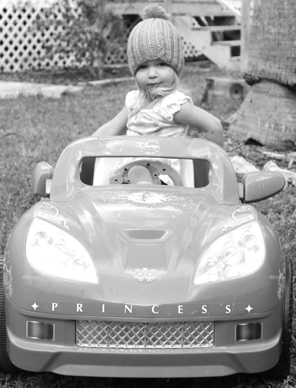 Little girl sitting in toy car