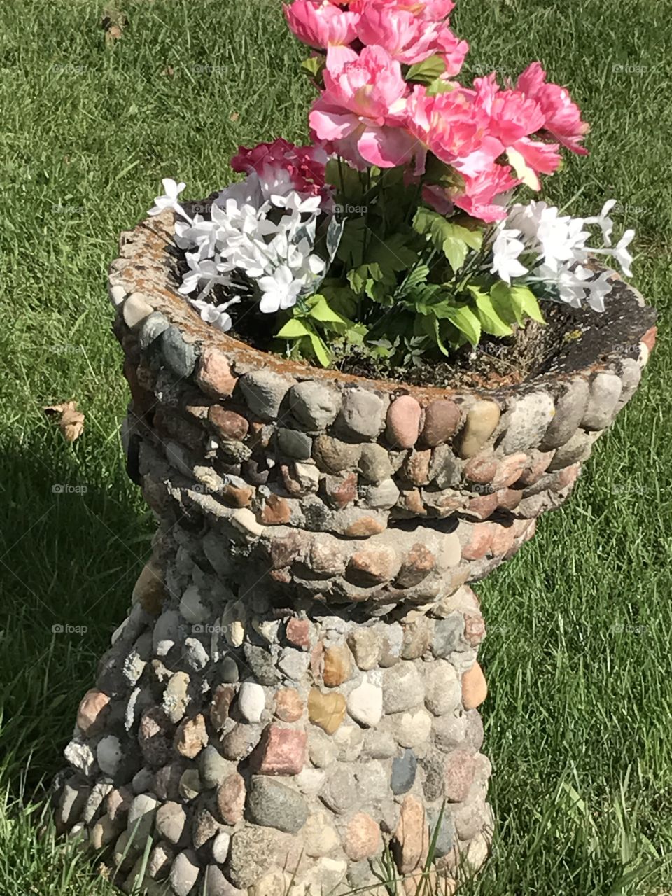 Leaning stone planter at a cemetery 