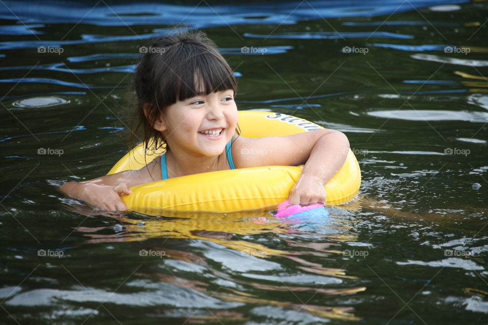 Smiley girl swimming in a lake