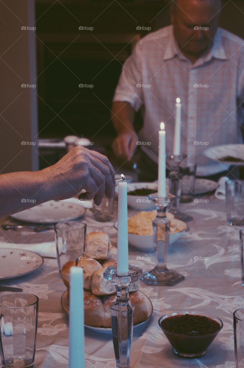 Human hand lighting up candle on dinning table
