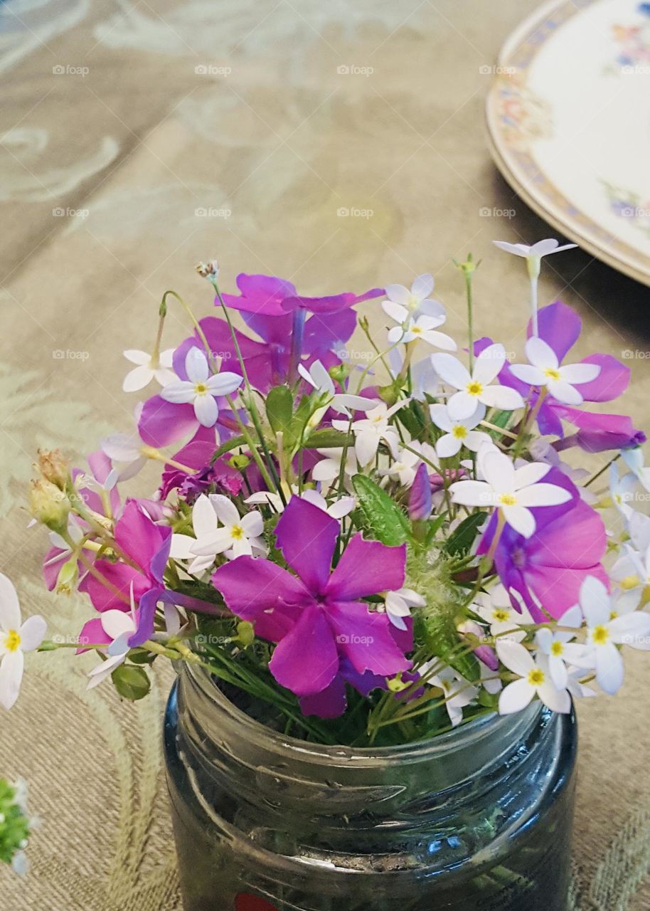 Fresh wildflowers in glass containers decorate a spring dining room table
