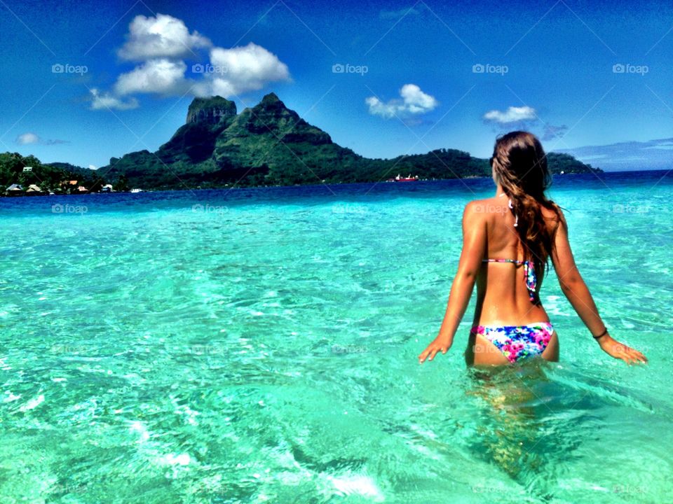 Woman in bikini standing in water at bora bora