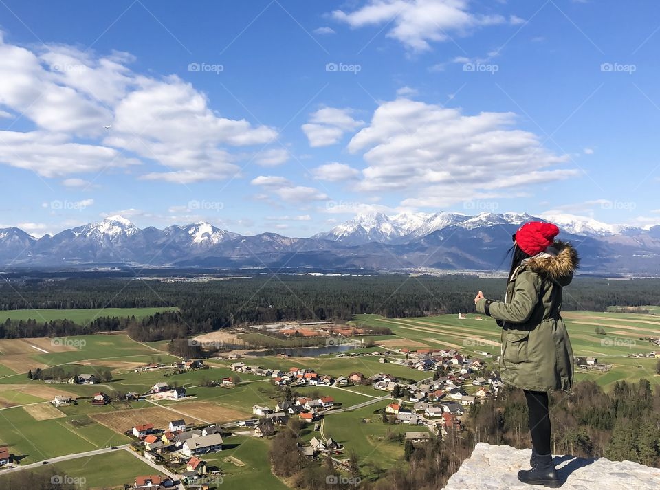 Female person enjoying view of flying plane above villages with background of mountains in Europe 