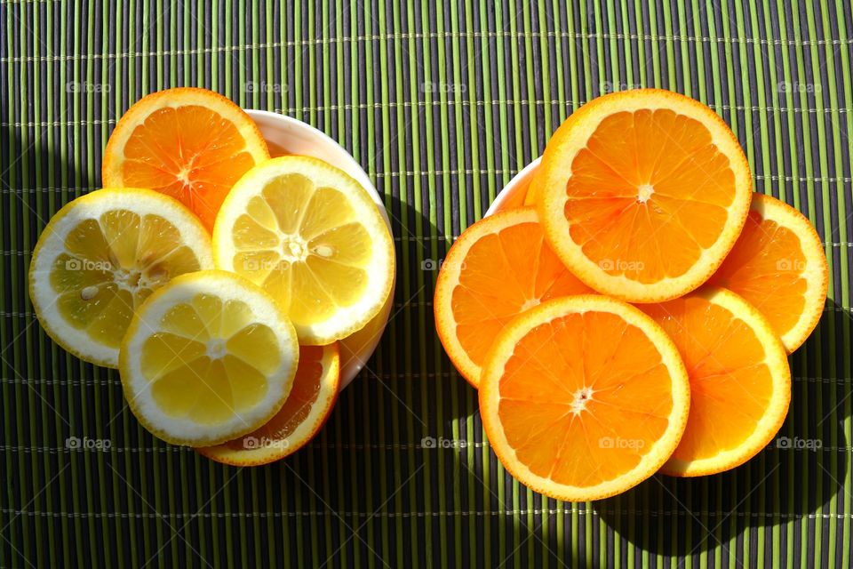 citrus fruits sliced on a plate green table top view solar background