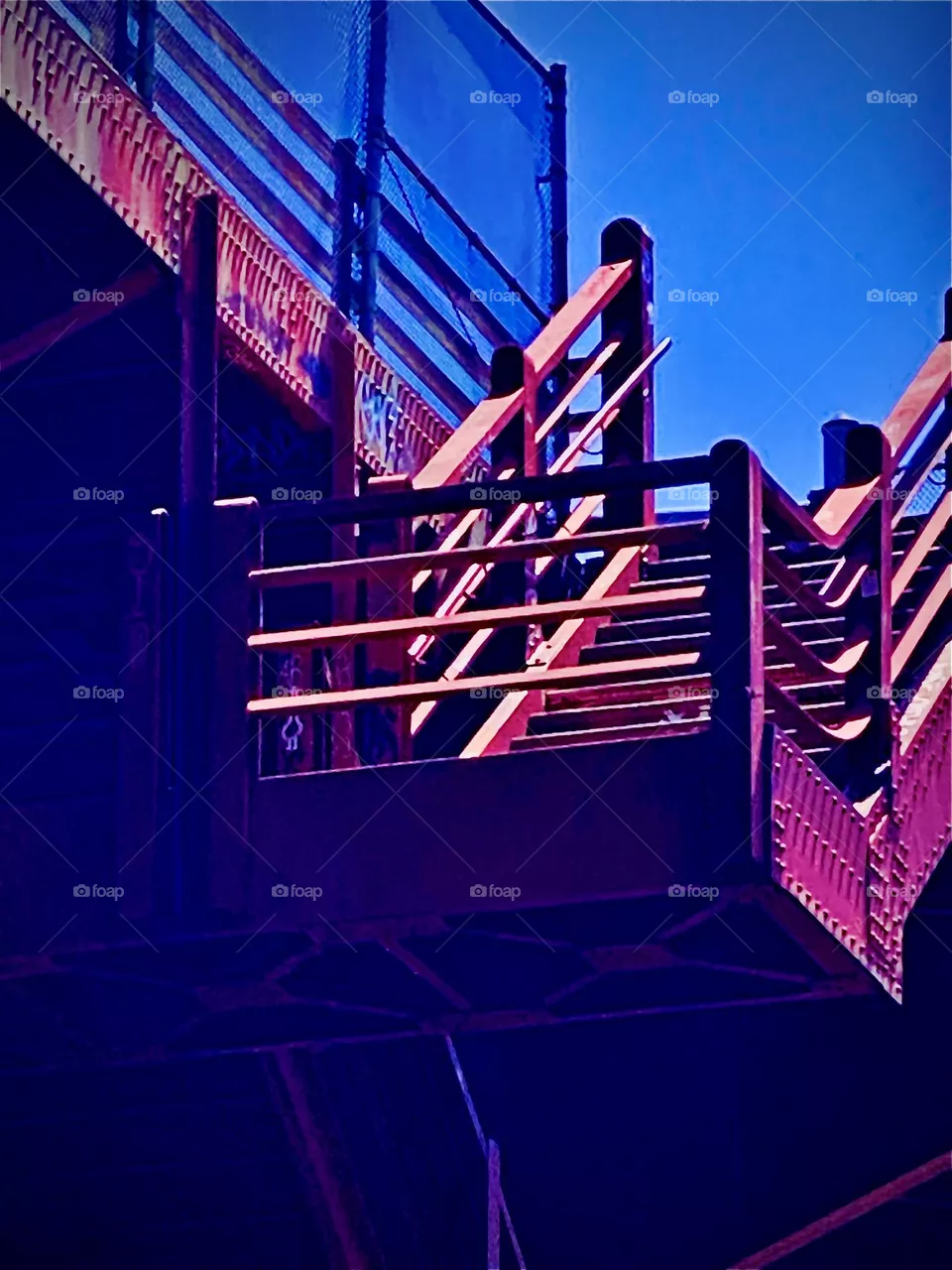 The red metal staircase goes up to the „Pulaski Bridge“ in LIC, Queens that leads to „Greenpoint“, Bklyn. It’s a prime example of urban industrialist design that is functional & practically oriented but also attractive. 2022. Hypnotic Productions